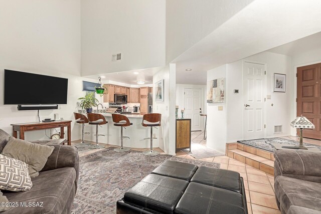 tiled living room with a towering ceiling