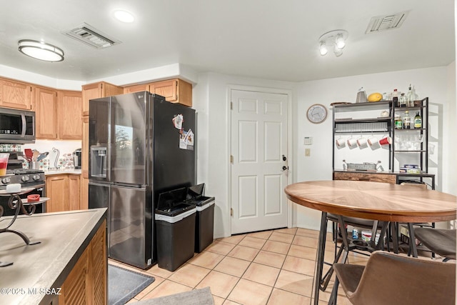 kitchen featuring appliances with stainless steel finishes, light countertops, visible vents, and light tile patterned flooring