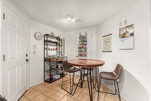 dining space featuring light tile patterned floors, visible vents, and baseboards