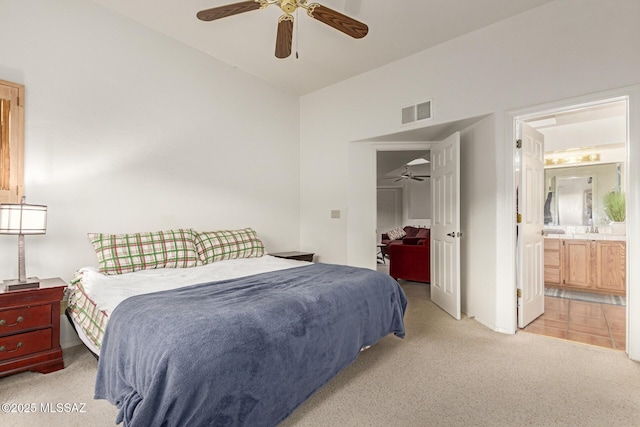 carpeted bedroom featuring ensuite bathroom, ceiling fan, and vaulted ceiling