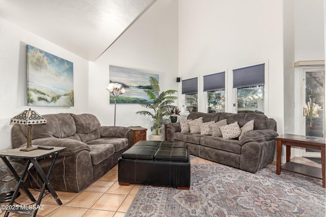 living room with a towering ceiling and light tile patterned floors