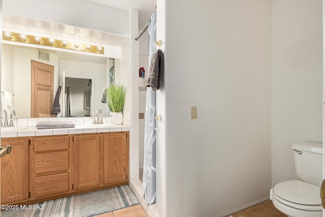 full bath with double vanity, visible vents, a shower with shower curtain, toilet, and tile patterned flooring