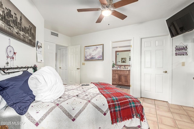 bedroom featuring light tile patterned floors, ceiling fan, ensuite bath, and visible vents