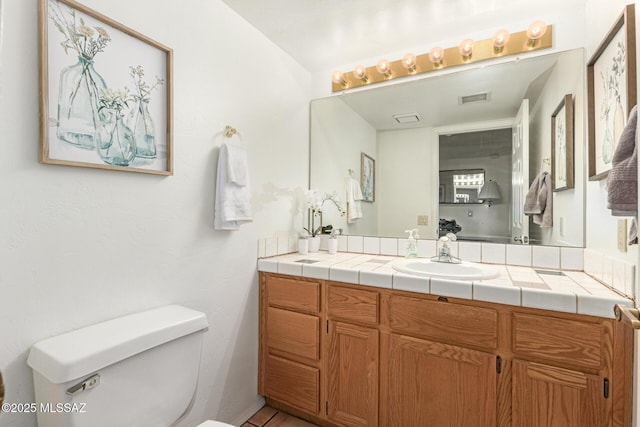 bathroom featuring toilet, visible vents, and vanity