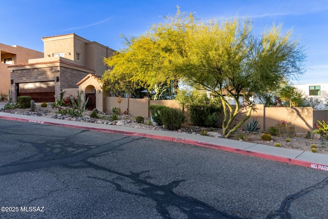 view of front of home with a fenced front yard and stucco siding