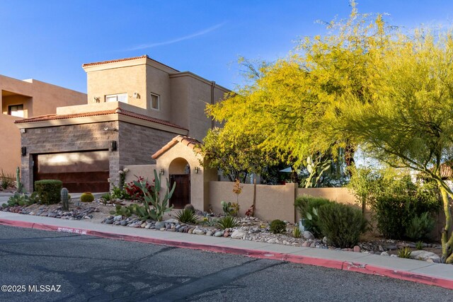 view of front facade with a fenced front yard, a tiled roof, and stucco siding