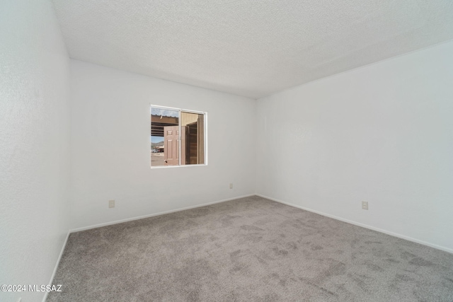 carpeted spare room with a textured ceiling