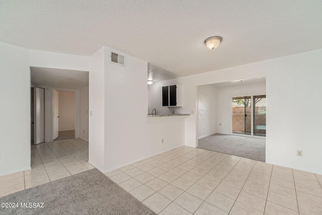 carpeted spare room with a textured ceiling