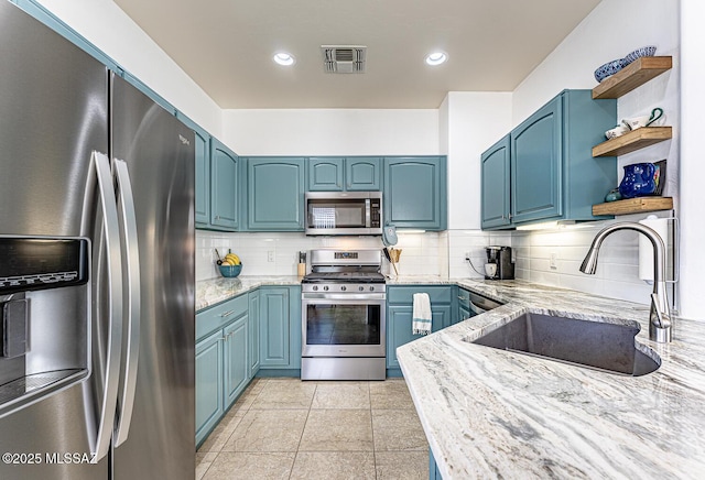 kitchen featuring sink, blue cabinetry, appliances with stainless steel finishes, tasteful backsplash, and light stone counters