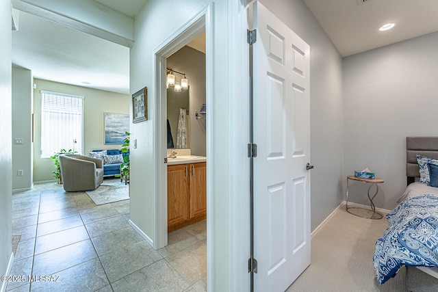 bedroom featuring ensuite bath and sink