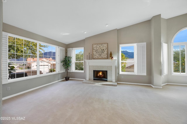 unfurnished living room featuring light carpet, a tile fireplace, and lofted ceiling