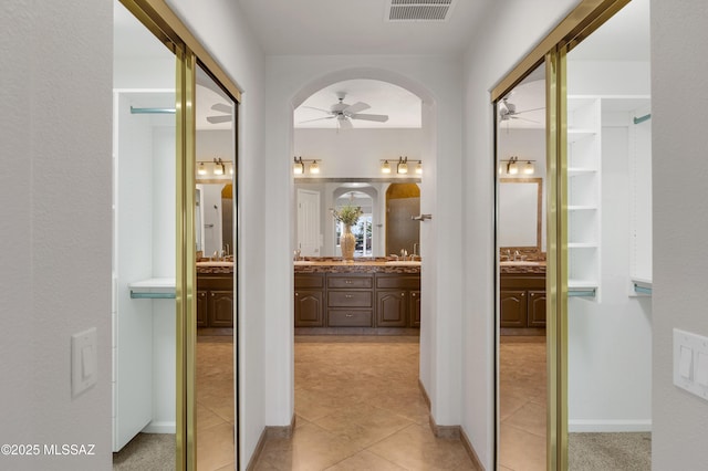 hallway featuring sink and light tile patterned floors