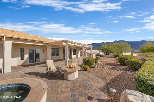 rear view of house featuring a pergola, a patio, a mountain view, and a fire pit