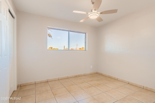 tiled spare room with ceiling fan