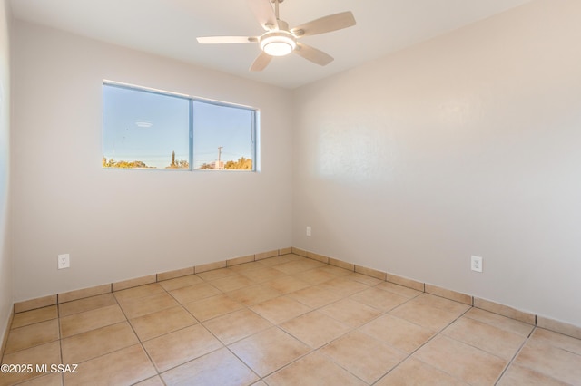 tiled spare room featuring ceiling fan