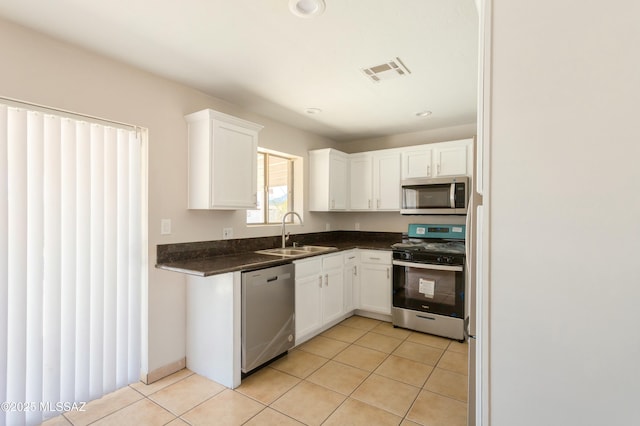 kitchen featuring white cabinetry, appliances with stainless steel finishes, sink, and light tile patterned floors