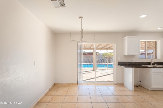 interior space featuring an inviting chandelier, sink, and light tile patterned flooring