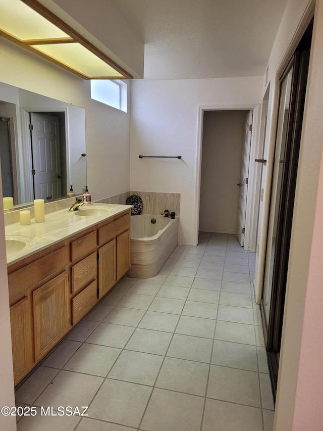 bathroom featuring a washtub, vanity, and tile patterned flooring