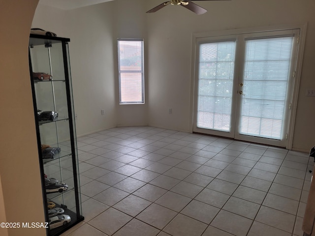 tiled spare room featuring ceiling fan