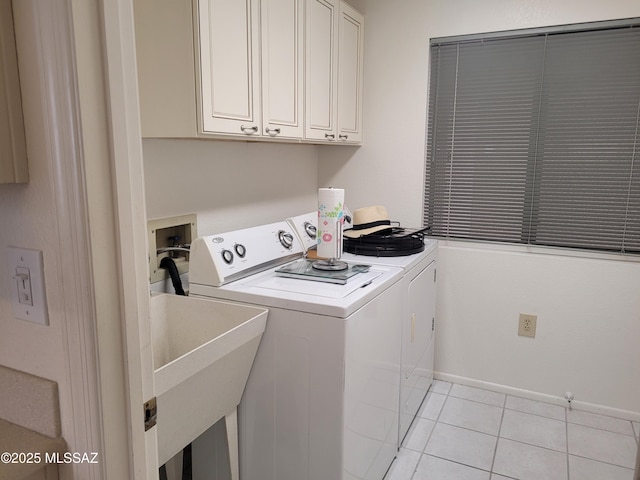 laundry room with cabinets, washing machine and dryer, light tile patterned floors, and sink