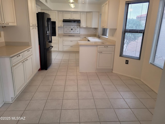 kitchen with light tile patterned flooring, sink, and black appliances