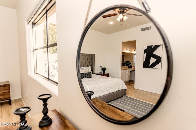 interior space featuring light wood-type flooring, ceiling fan, and ensuite bathroom