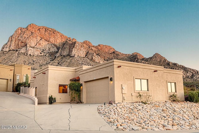 pueblo-style house featuring a mountain view and a garage