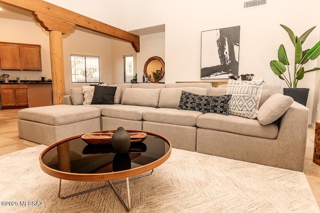 living room with decorative columns and beam ceiling