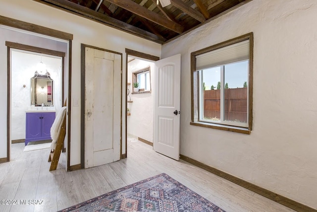 hall with light hardwood / wood-style flooring, beamed ceiling, and wooden ceiling