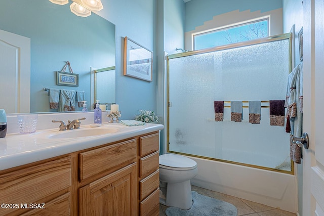 full bathroom with toilet, tile patterned flooring, vanity, and combined bath / shower with glass door