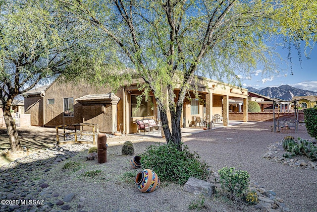 rear view of house featuring a mountain view and a patio area