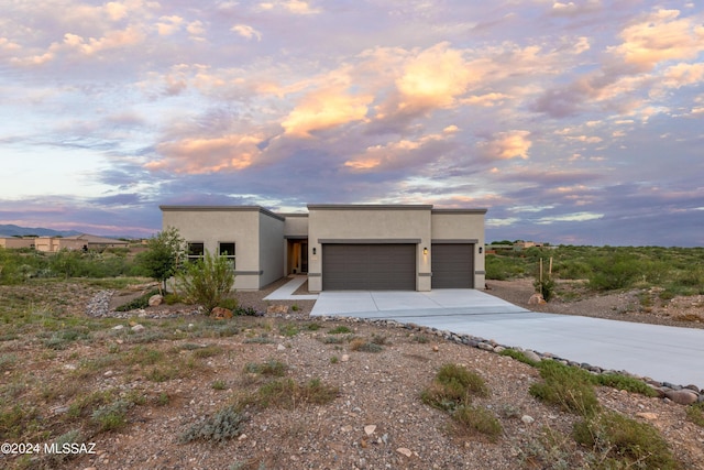 pueblo revival-style home featuring a garage