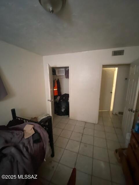 bedroom with light tile patterned floors and a closet