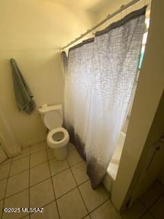 bathroom featuring tile patterned flooring, shower / bath combo, and toilet