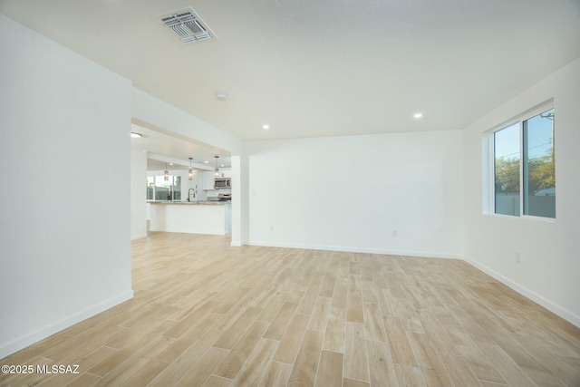 unfurnished living room featuring light hardwood / wood-style flooring and sink