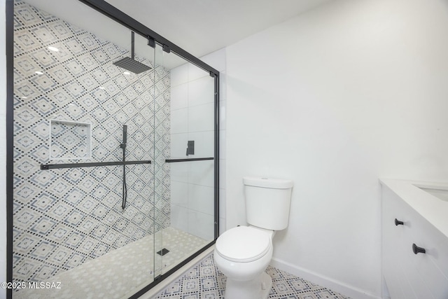 bathroom featuring tile patterned floors, vanity, a shower with shower door, and toilet