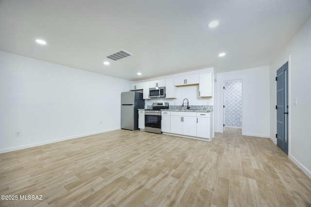 kitchen featuring white cabinets, light wood-type flooring, sink, and appliances with stainless steel finishes