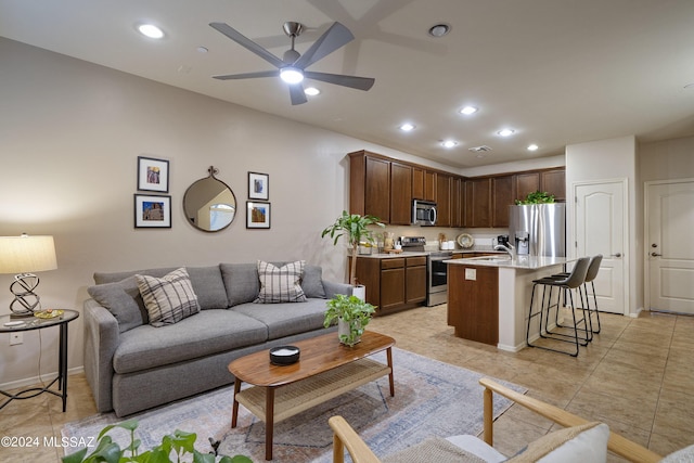 living room featuring ceiling fan and sink