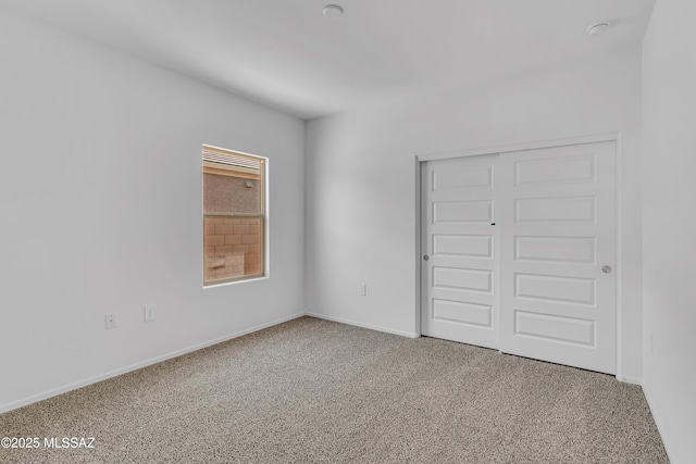 unfurnished bedroom featuring carpet floors and a closet