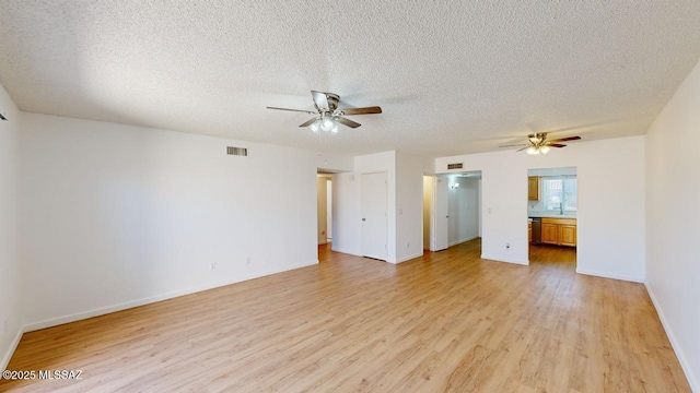 spare room with ceiling fan, sink, light hardwood / wood-style floors, and a textured ceiling