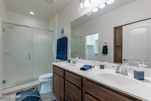 bathroom featuring walk in shower, vanity, toilet, and tile patterned flooring