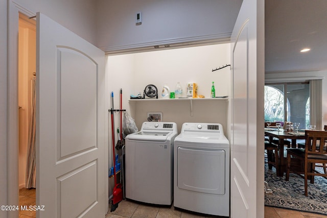 laundry room featuring washing machine and dryer and light tile patterned floors