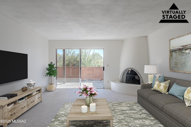 carpeted living room with a large fireplace and a textured ceiling