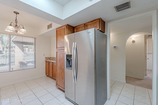 kitchen with a chandelier, stainless steel fridge, decorative light fixtures, and light tile patterned floors