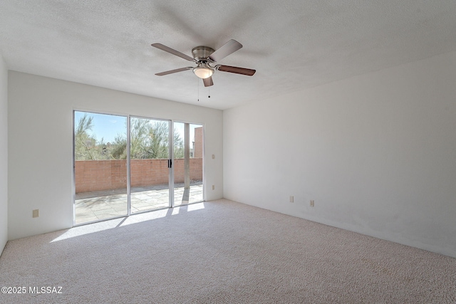 unfurnished room featuring a textured ceiling, ceiling fan, and light colored carpet