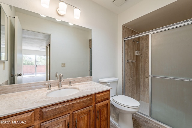 bathroom featuring vanity, an enclosed shower, and toilet