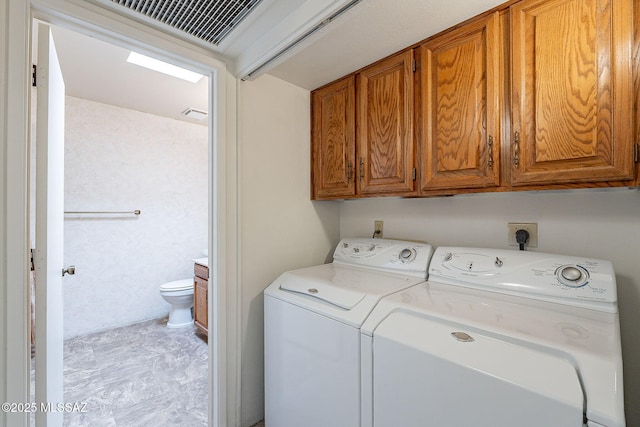 laundry area with washing machine and dryer and cabinets