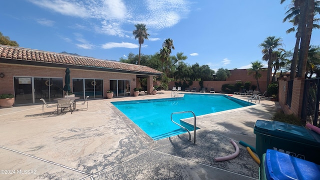 community pool with fence and a patio