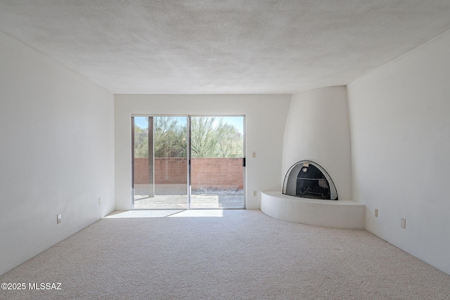 unfurnished living room with light carpet and a textured ceiling