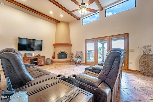 living room with ceiling fan, french doors, a high ceiling, beamed ceiling, and a fireplace